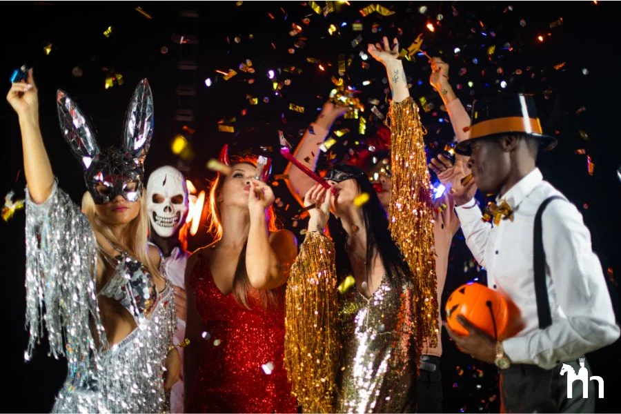 Verkleidet Menschen zu Halloween mit Glitzerkost&uuml;men, Masken und Halloween Deko.