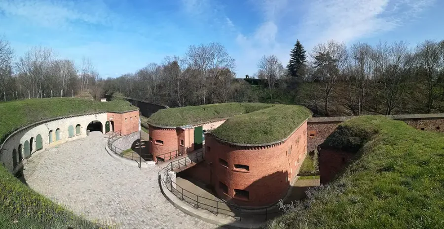 Ravelin 2 bei Tag: halbrund angeordnete Backsteinkasematten mit begr&uuml;nten Erdw&auml;llen und gepflastertem Innenhof