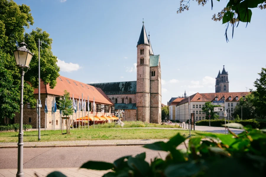 Kloster Unser Lieben Frauen von der Wiese aus: Rundturm und kupfergedecktes Dach &uuml;ber dem Klosterhof, rechts im Hintergrund ein Domturm
