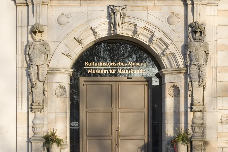 Sandsteinportal mit zwei Ritterreliefs und goldenem Schriftzug &bdquo;Kulturhistorisches Museum &ndash; Museum f&uuml;r Naturkunde" &uuml;ber der Bronzet&uuml;r